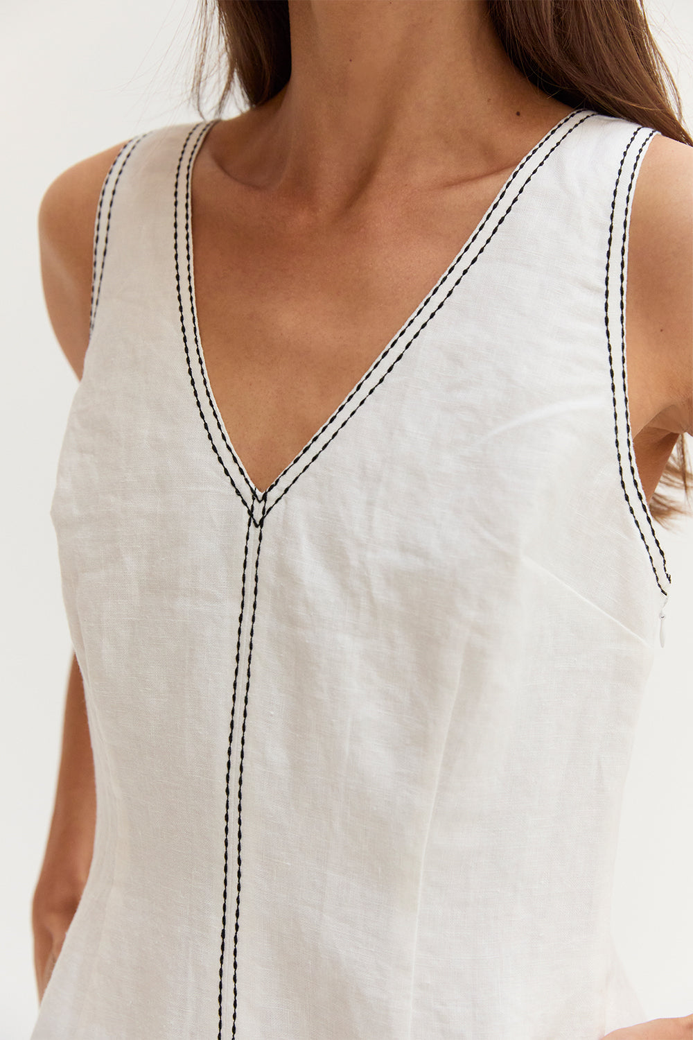 Mini-robe en lin sans manches à col en V et surpiqûres contrastantes blanches