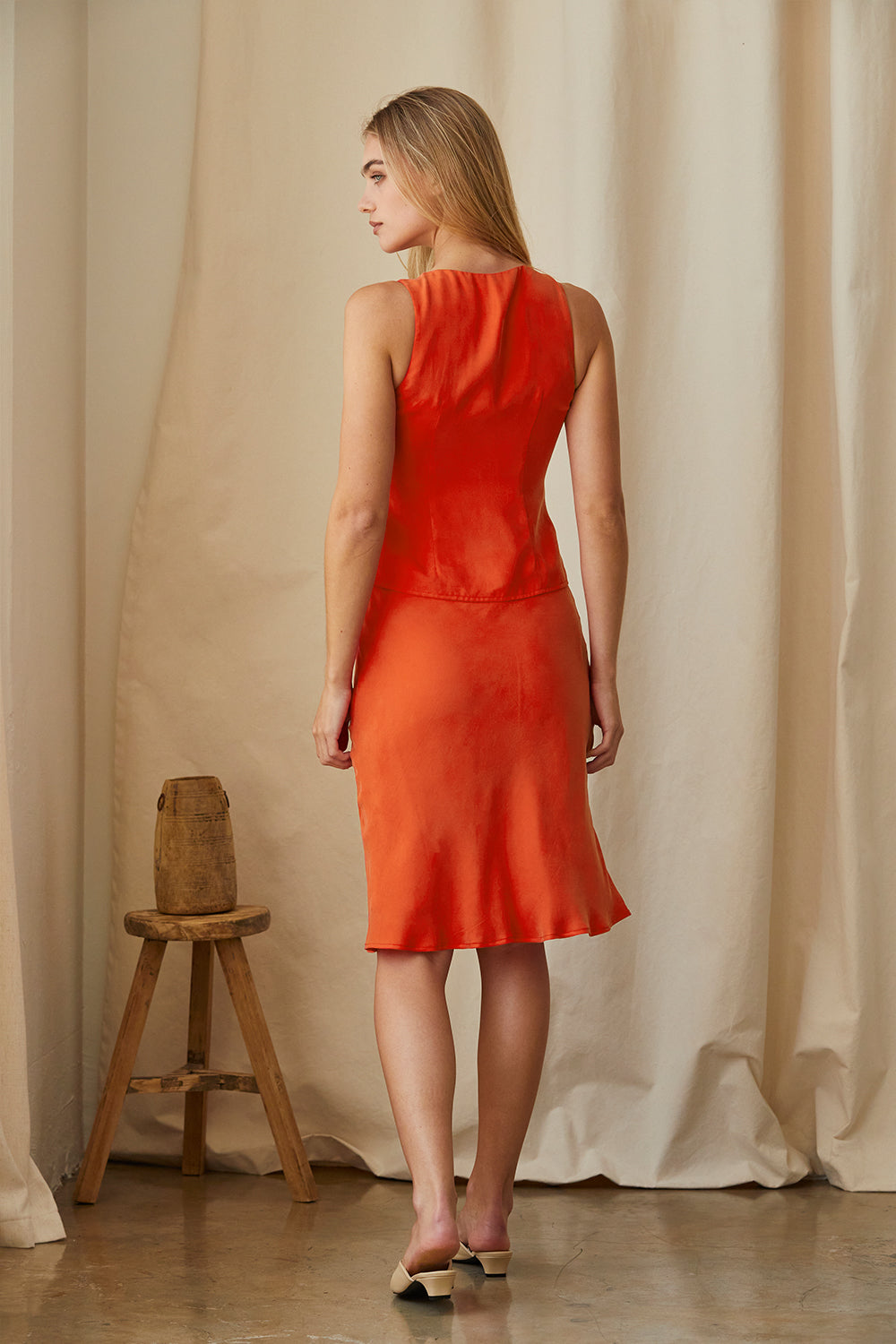 Jupe midi longueur thé en cupro rouge coquelicot, silhouette fluide, fermeture éclair latérale